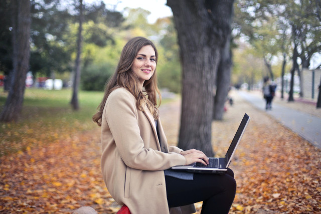 A woman in the parj with a laptop