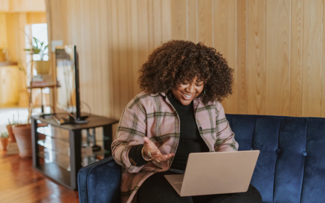 Woman with laptop on blue sofa